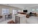 An open living area and kitchen featuring an island sink, dining area and back yard views from sliding glass doors at 387 Larksong Ave, Henderson, NV 89011