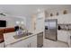 An open-concept kitchen island connects to the living area with stainless steel appliances and bright natural light at 387 Larksong Ave, Henderson, NV 89011