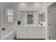 Bathroom featuring a double sink vanity, soaking tub, and large mirror at 40 Strada Moscato, Henderson, NV 89011