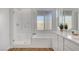 Bright bathroom with a glass enclosed shower, soaking tub, and double sink vanity at 40 Strada Moscato, Henderson, NV 89011