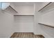 Walk-in closet featuring wall to wall shelves and neutral carpet at 40 Strada Moscato, Henderson, NV 89011