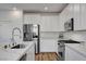 Modern kitchen with white cabinets, stainless steel appliances, and quartz countertops at 40 Strada Moscato, Henderson, NV 89011