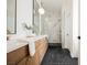 Modern bathroom featuring a double sink vanity, marble walk-in shower and black tile flooring at 4065 Genoa Dr, Las Vegas, NV 89141