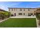 Beautiful two-story home with a large backyard featuring lush green turf and a covered patio area at 4220 San Alivia Ct, Las Vegas, NV 89141