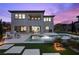 Backyard with a pool, spa, outdoor kitchen, covered patio, and putting green at twilight at 4220 San Alivia Ct, Las Vegas, NV 89141