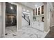 Stylish bar area with marble floors, custom cabinetry and access to the dining room and staircase at 4220 San Alivia Ct, Las Vegas, NV 89141