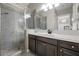 Modern bathroom with a glass-enclosed shower, a gray vanity, and stylish lighting fixtures at 4220 San Alivia Ct, Las Vegas, NV 89141