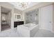 Modern bathroom with a soaking tub, glass-enclosed shower, an illuminated mirror and marble tile flooring at 4220 San Alivia Ct, Las Vegas, NV 89141