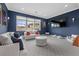 Cozy bonus room with blue accent walls, white sofas, and ample seating for relaxation at 4220 San Alivia Ct, Las Vegas, NV 89141