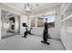 Well-lit exercise room with two exercise bikes and view into sitting area with fireplace at 4220 San Alivia Ct, Las Vegas, NV 89141