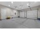 Spacious three-car garage with epoxy flooring, two garage doors, and overhead lighting at 4220 San Alivia Ct, Las Vegas, NV 89141