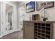 Stylish hallway with a mirrored door, artwork, and a decorative cabinet with wine storage at 4220 San Alivia Ct, Las Vegas, NV 89141