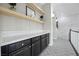 Hallway featuring a built-in bar area with shelving, counter space, and dark cabinets at 4220 San Alivia Ct, Las Vegas, NV 89141