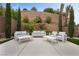 Outdoor patio with comfortable seating and sleek tables surrounded by beautiful landscaping and hardscape at 4220 San Alivia Ct, Las Vegas, NV 89141