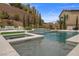 Stunning backyard pool and spa area with a waterfall feature, surrounded by lush landscaping at 4220 San Alivia Ct, Las Vegas, NV 89141
