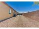 Expansive backyard featuring decorative rock, palm trees, privacy wall and side of house at 4260 Helena Cove Ct, Las Vegas, NV 89129