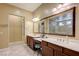 Elegant bathroom featuring dual sinks, vanity area, and a large framed mirror at 4260 Helena Cove Ct, Las Vegas, NV 89129