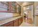 Butler's pantry featuring granite counters, wood cabinets with glass doors, and tile flooring at 4260 Helena Cove Ct, Las Vegas, NV 89129