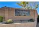 A monument sign with the Woodland Crest neighborhood name is landscaped with shrubbery at 4260 Helena Cove Ct, Las Vegas, NV 89129