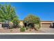 Single-story home features a mature shade tree, desert landscaping, and a two-car garage at 4260 Helena Cove Ct, Las Vegas, NV 89129