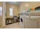 This laundry room has a stainless steel sink, tile floors, and white appliances at 4260 Helena Cove Ct, Las Vegas, NV 89129
