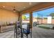 Inviting covered patio featuring tiled floors, ceiling fan, outdoor dining, and golf practice net at 4260 Helena Cove Ct, Las Vegas, NV 89129
