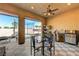 Inviting covered patio featuring tiled floors, ceiling fan, outdoor dining, and grill at 4260 Helena Cove Ct, Las Vegas, NV 89129