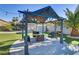 Shaded gazebo in a backyard featuring manicured landscaping and outdoor seating at 4474 Dawley Ct, Las Vegas, NV 89104