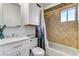 Bright bathroom featuring a tiled shower-tub combo, white vanity with a marble top, and ample storage at 4474 Dawley Ct, Las Vegas, NV 89104