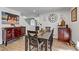 Dining room featuring a rustic wooden table, elegant chairs, and stylish accent furniture on a tiled floor at 4474 Dawley Ct, Las Vegas, NV 89104