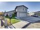 Two-story house featuring a gray exterior, attached garage, and well-maintained front yard with green grass at 4474 Dawley Ct, Las Vegas, NV 89104