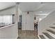 Hallway that opens to the living area featuring hard surface floors, light walls and adjacent staircase at 4474 Dawley Ct, Las Vegas, NV 89104