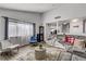 Comfortable living room with modern gray sofa, area rug, and bright natural light from large windows at 4474 Dawley Ct, Las Vegas, NV 89104