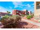 Exterior view of a red stucco multi-story condo building with steel staircase and landscaping at 4730 E Craig Rd # 1115, Las Vegas, NV 89115