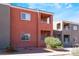 Exterior view of a red stucco multi-story condo building with a balcony at 4730 E Craig Rd # 1115, Las Vegas, NV 89115