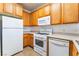 Functional kitchen features white appliances, wooden cabinets and efficient layout at 4730 E Craig Rd # 1115, Las Vegas, NV 89115