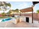 Outdoor kitchen featuring a built-in grill, counter space, and view of the pool and gazebo at 4764 Lana Dr, Las Vegas, NV 89121