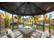 Gazebo featuring a fire pit table, seating, with a view of the pool and backyard at 4764 Lana Dr, Las Vegas, NV 89121