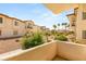Balcony view of stucco buildings with tile roofs and desert landscaping at 4830 Grey Wolf Ln # 104, Las Vegas, NV 89149