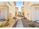 View down walkway between stucco homes with desert landscaping and shared green space at 4830 Grey Wolf Ln # 104, Las Vegas, NV 89149