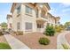 Beautiful stucco condominium building with tile roof, balconies, desert landscaping, and walkways at 4830 Grey Wolf Ln # 104, Las Vegas, NV 89149