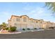 Townhome boasts multi car garage, lush landscaping and beige stucco at 4830 Grey Wolf Ln # 104, Las Vegas, NV 89149