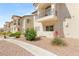 Attractive stucco condominium building with tile roof, balconies, desert landscaping, and walkways at 4830 Grey Wolf Ln # 104, Las Vegas, NV 89149