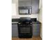 This is a kitchen with black appliances, grey cabinets, and tile flooring at 4910 Elizabeth St, Pahrump, NV 89048