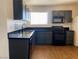 This is a kitchen with black appliances, grey cabinets, and tile flooring at 4910 Elizabeth St, Pahrump, NV 89048