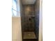 Modern shower featuring dark tiling and a shower head at 4910 Elizabeth St, Pahrump, NV 89048