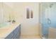 Bright bathroom featuring a dual sink vanity with a gray cabinet and glass shower at 5400 E Grain Mill Rd, Pahrump, NV 89061