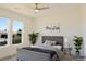 Virtually staged bedroom with gray bed and ample natural light at 5400 E Grain Mill Rd, Pahrump, NV 89061