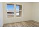 Bright bedroom with light wood flooring, white walls, and two large windows at 5400 E Grain Mill Rd, Pahrump, NV 89061