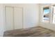 Bedroom with wood laminate flooring, windows, and closet with sliding doors at 5400 E Grain Mill Rd, Pahrump, NV 89061